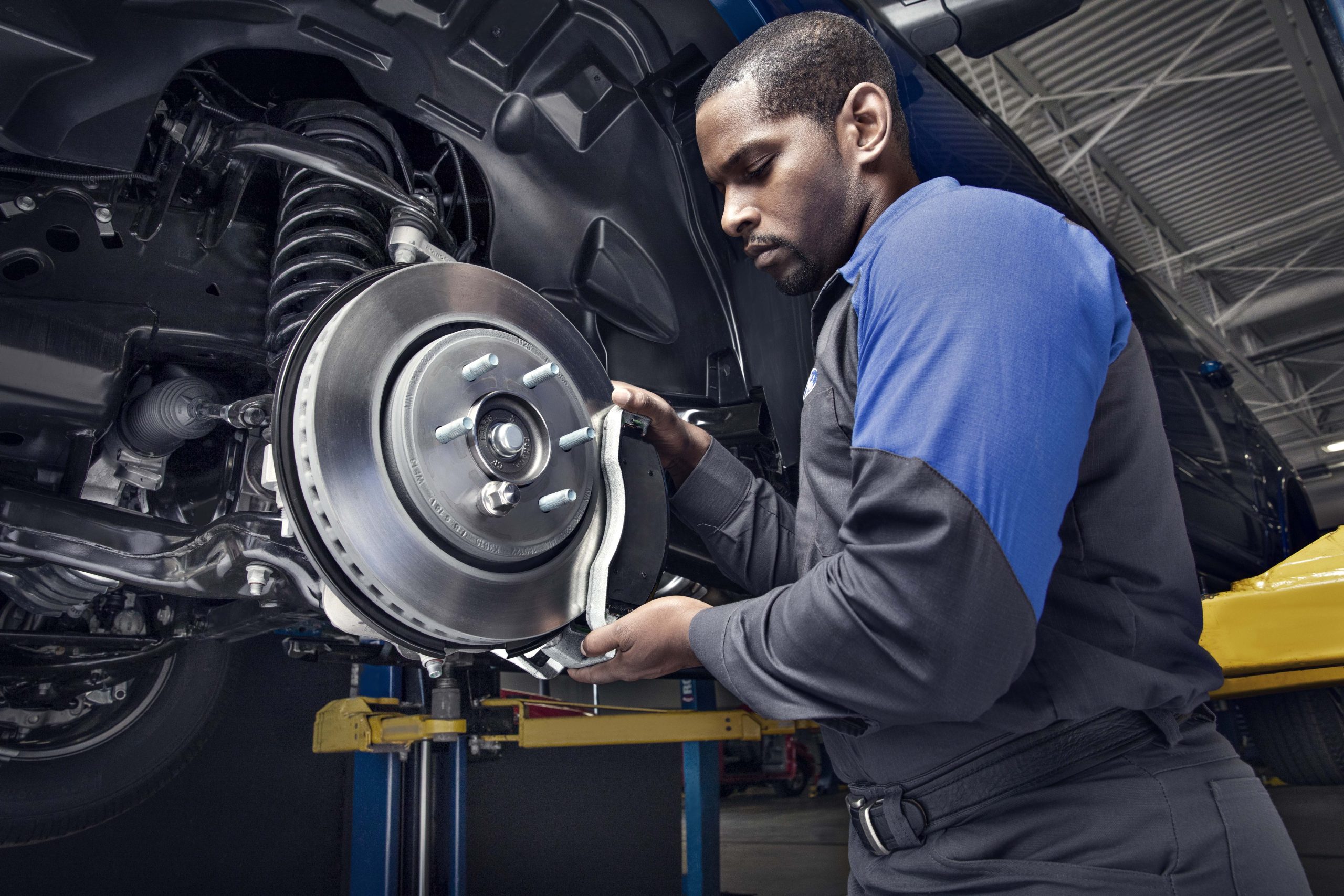 A mechanic working on a car's brake system.