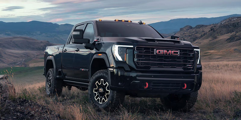 A black GMC Sierra 2500HD truck parked in a rugged, mountainous landscape